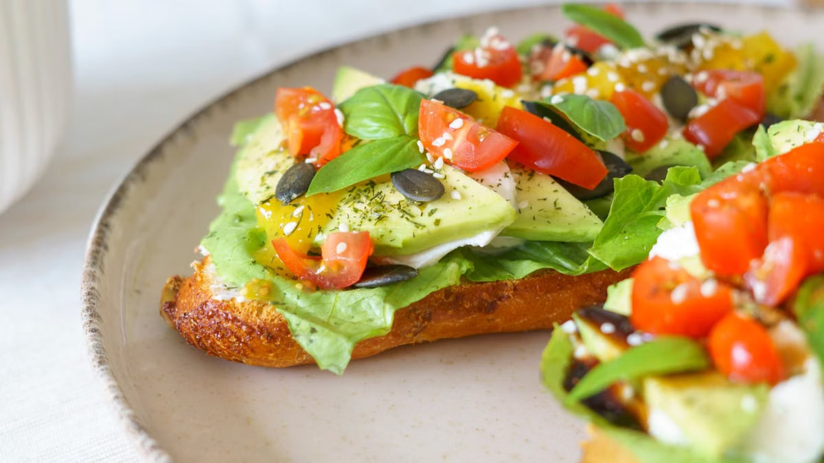 Close-up of vibrant avocado toast with fresh vegetables, perfect for healthy vegan meals.